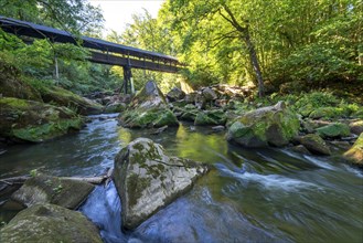 The Irrel Waterfalls, rapids in the lower reaches of the Prüm, covered wooden bridge for hikers,