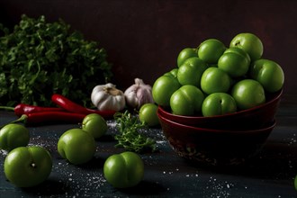 Tkemali, green cherry plum, with ingredients for sauce, cilantro, mint, hot pepper, garlic, on a