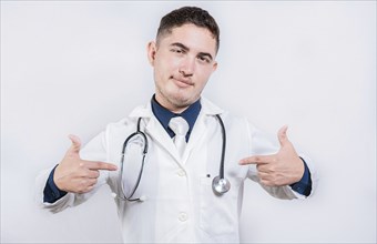 Cheerful doctor pointing at himself isolated. Satisfied young doctor pointing at himself on