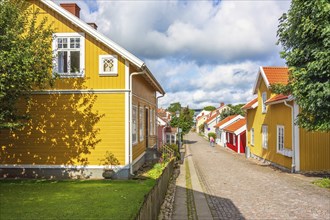 Idyllic old wooden cottages with a cobblestone street in an old swedish town a sunny summer day,