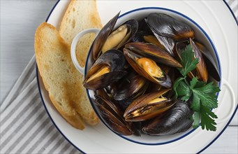 Fresh, Boiled mussels, Black Sea, with white bread, on a white wooden table, no people