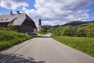 Street with Black Forest house and the church of St. Johann in the Innerlehen district, Bernau im