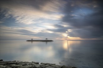 Beautiful seascape in the morning. Tropical sandy beach with breakwater and reflection of the sky