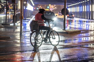 Street at the central station, cyclist, rainy weather, city centre, in the evening, Essen, North