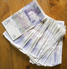 Â£20 sterling pound notes on a wooden table from above, UK