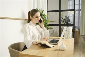 A young woman advises a client by phone, gives information and provides support