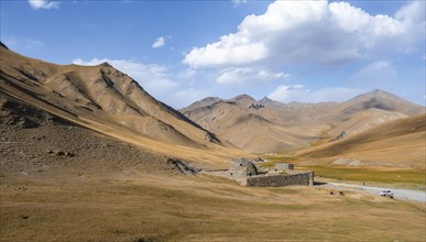 Historic caravanserai Tash Rabat from the 15th century, in the evening light with golden hills,