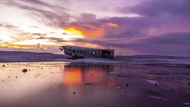 Beautiful aerial drone view at sunrise on crashed plane on frozen Solheimasandur beach in winter,