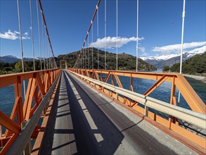 Wideangle view of famous orange suspension bridge Puente General Carrera, at lake Lago General