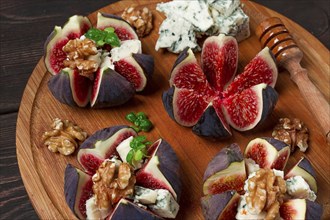 Appetizer, Figs with blue cheese, walnut, honey, on a wooden board, top view, close-up, no people