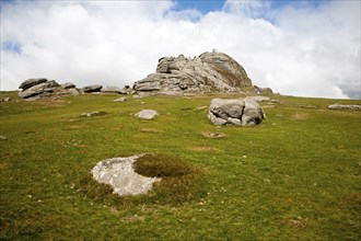 People scrambling on the granite tor of Haytor, Dartmoor national park, Devon, England, United