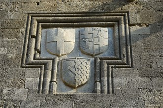 Relief with three coats of arms in a rectangular stone frame on a medieval wall, Knights' Street,