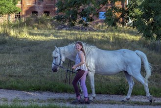 Girl, 10 years old leads her horse on the lead, Othenstorf, Mecklenburg-Vorpommern, Germany, Europe