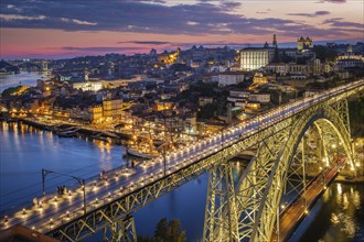 View of illuminated Porto city and Douro river and Dom Luis bridge I from famous tourist viewpoint