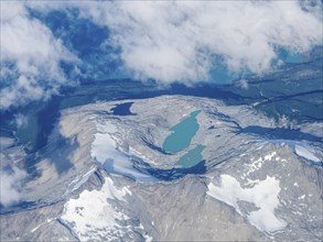 Mountains, white clouds and green lakes, flight over Patagonia, Chile, South America