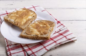 Sandwiches with pollock roe on a white plate, on a white wooden background with copy space