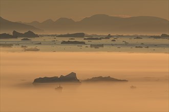 Boats in front of icebergs in the fog, midnight sun, summer, Ilulissat, Ilulissat Icefjord, Disko