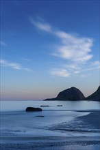 Seascape on the beach at Haukland. The sky is blue. At night at the time of the midnight sun in