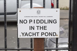 Funny sign saying No Piddling in the Yacht Pond paddling pool at Aldeburgh, Suffolk, England, UK