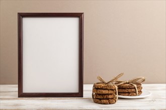 Wooden frame with oatmeal cookies on beige pastel background. side view, copy space, still life,