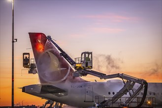 Frost at the airport, a Turkish Airlines aircraft is de-iced in front of sunrise. Airbus A321-231,