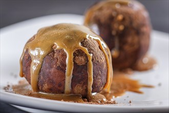 Energy balls cakes with chocolate and caramel on white plate on black background. selective focus,