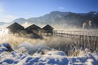 Boat huts in the morning light in front of mountains, lake, snow, winter, fog, Lake Kochel, Alpine