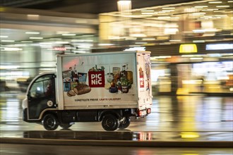 Picnic food delivery service vehicle, rainy weather, city centre, in the evening, Essen, North