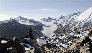 Cairn on the hiking trail to Ramoljoch with snow in autumn, mountain panorama and glacier, view of