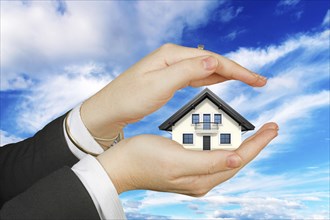 Symbol photo, Two hands protect a home, Women's hands, Studio