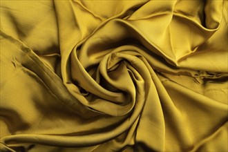 Fragment of yellow and green tissue. Side view, synthetic textile background and texture. wave