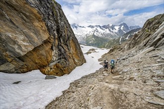 Mountaineer on a hiking trail next to a large boulder, ascent to the Nördliche Mörchnerscharte,