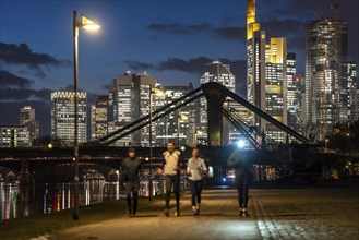 Skyline of the city centre of Frankfurt am Main, joggers on the pavement, promenade along the river