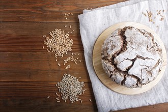 Yeast free homemade bread with whole rye and wheat grains on rustic wooden background. Top view,