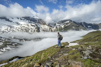 Mountaineer on a hiking trail with high fog in the valley, summit Hochfeiler, Hoher WeiÃŸzint and