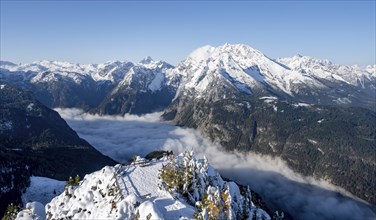 Tourist with camera on a hiking trail, Snow-covered summit of the Jenner with viewing platform in