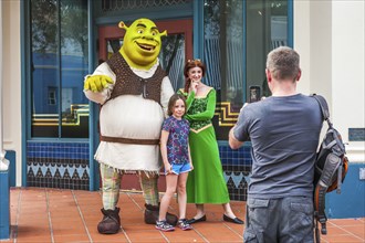 Man photographing daughter with Shrek and Princess Fiona at Universal Studios theme park in