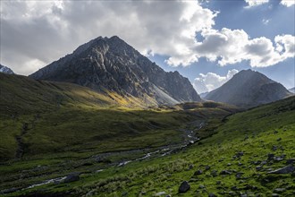 Green high valley with mountain stream, Keldike Valley on the way to the Ala Kul Pass, Tien Shan