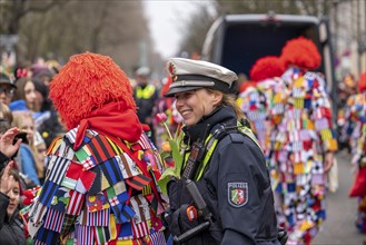 Rose Monday parade in Düsseldorf, policemen on duty at the street carnival, with flower