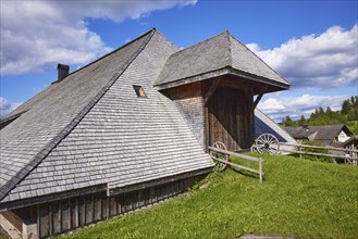 Entrance gate to a Black Forest house with old wagon wheels of the Resenhof Farm Museum in the