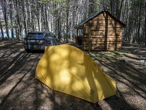 Tent and rental car on campground at the Jeinimeni NP, wooden shelter and sitting area, Patagonia,