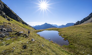 Hiker on the Carnic High Trail, small mountain lake, Carnic Main Ridge, Carnic Alps, Carinthia,