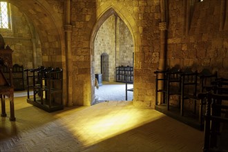 Church interior with incident sunlight and wooden chairs, Gothic architecture, Monastery of Our