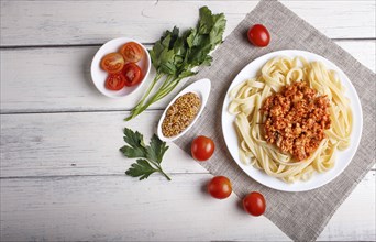 Fettuccine bolognese pasta with minced meat on white wooden background. top view, copy space