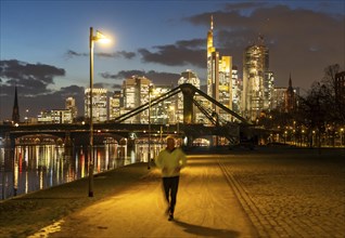 Skyline of the city centre of Frankfurt am Main, joggers on the pavement, promenade along the river