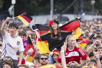 Football fans sitting on shoulders in the fan zone at the Brandenburg Tor during the quarter-final