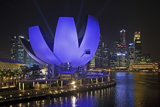 The purple illuminated ArtScience Museum and skyline with skyscrapers and high-rise buildings in