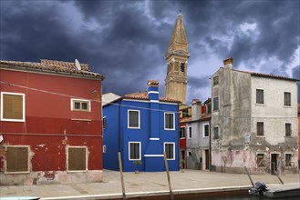 Colourful residential buildings, behind the leaning tower of the church of St. Martin Vescovo, 16th