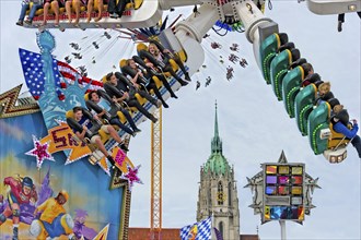 People whirling in carousel skater, ride on the Wies'n, Oktoberfest, Wiesn, behind parish church St