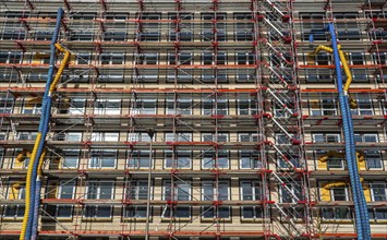 Large construction site, scaffolded shell of an office building complex, air hoses for building